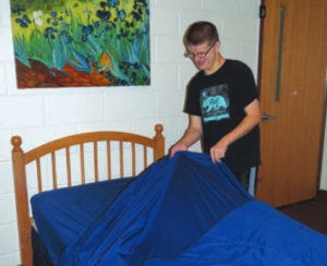 Larc School student making a bed