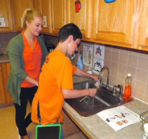 Larc School student washing dishes