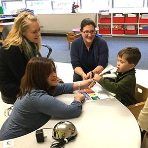 Teachers and aides working with a male Larc School Preschool student