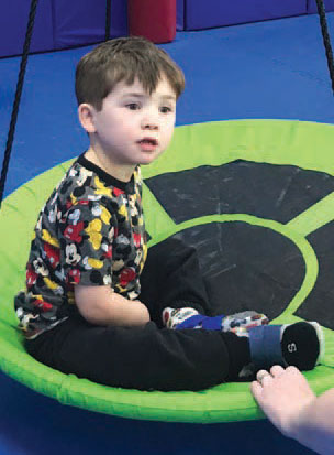 Young male student on swing at after school activity